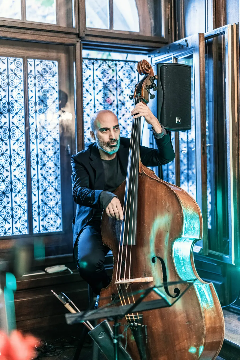 Kontrabassist spielt live vor einem bunten Glasfenster