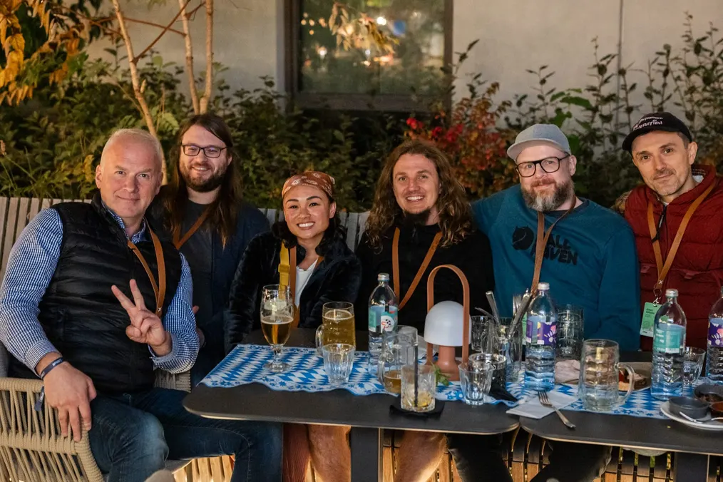 Teilnehmende beim Oktoberfest-Abend an einer blau-weiß gedeckten Tafel