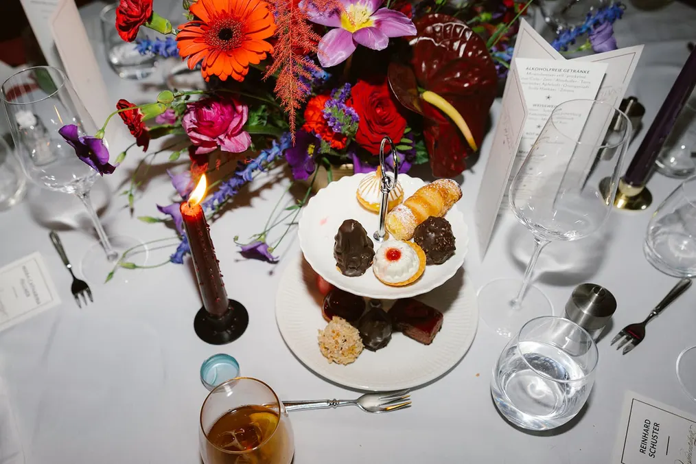 Tischdekoration mit Blumen und Dessert von oben