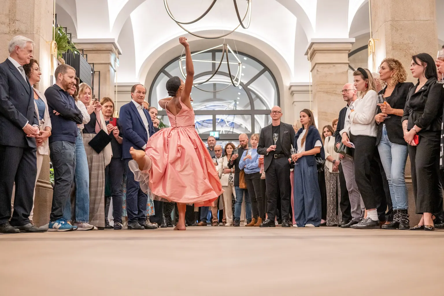 Tänzerin im rosa Ballkleid performt vor den Gästen in der historischen Halle der Imperial Riding School